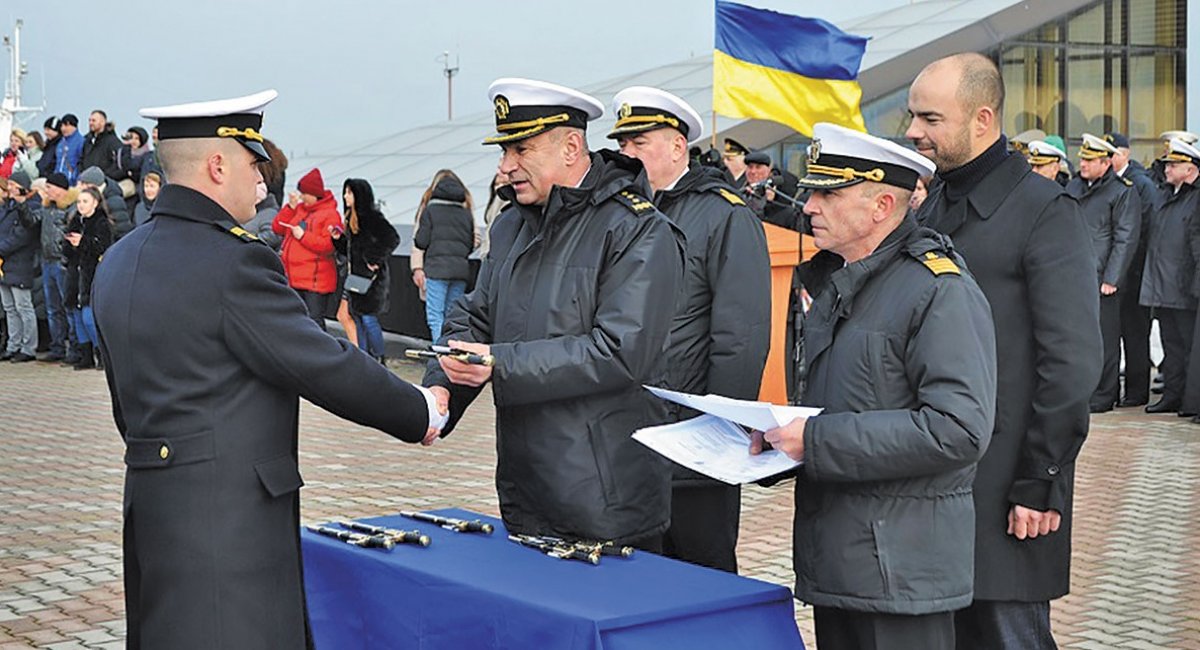 Адмірал Ігор Воронченко вручає молодому офіцерові кортик, погони і диплом